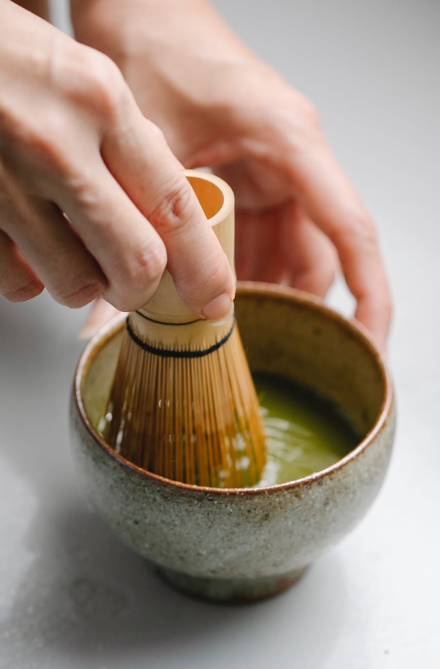 close up photo of person preparing ceremonial tea drink